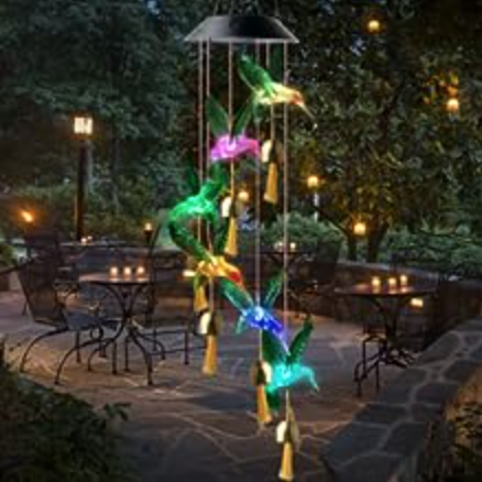 Hummingbird Solar Wind Chime hanging in a garden in the evening