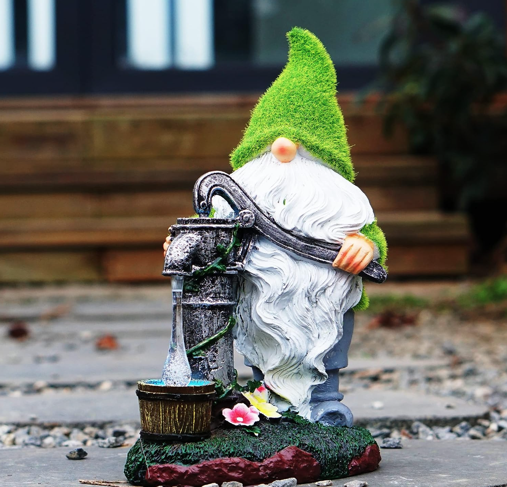 Funny gnome with waterpump outside in front of a house