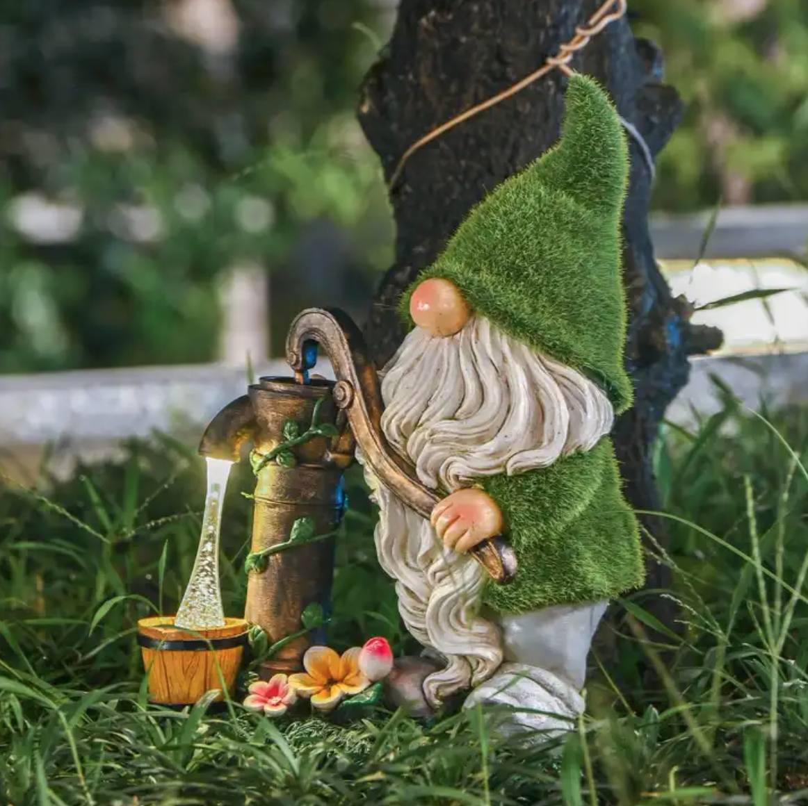 Gnome with green flocked hat, getting water from a water pump.